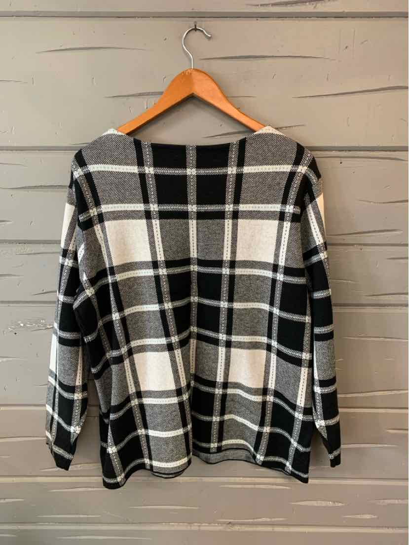 Black and white plaid long-sleeve top with relaxed fit, shown from the back on wooden hanger.