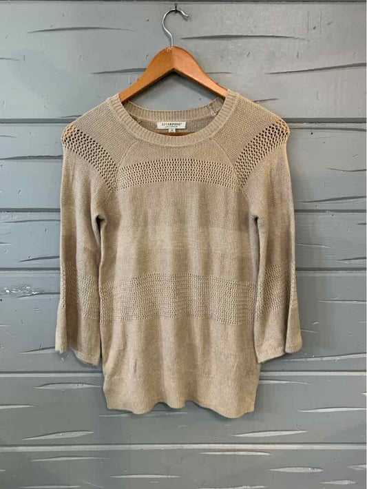 Tan knitted long-sleeve sweater with ribbed neckline and textured shoulder details.