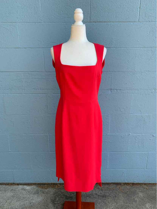 Red sleeveless knee-length dress with square neckline on mannequin.