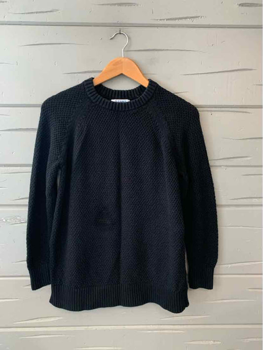 Black long-sleeve knit sweater with crew neck, ribbed cuffs, and hem on wooden hanger.
