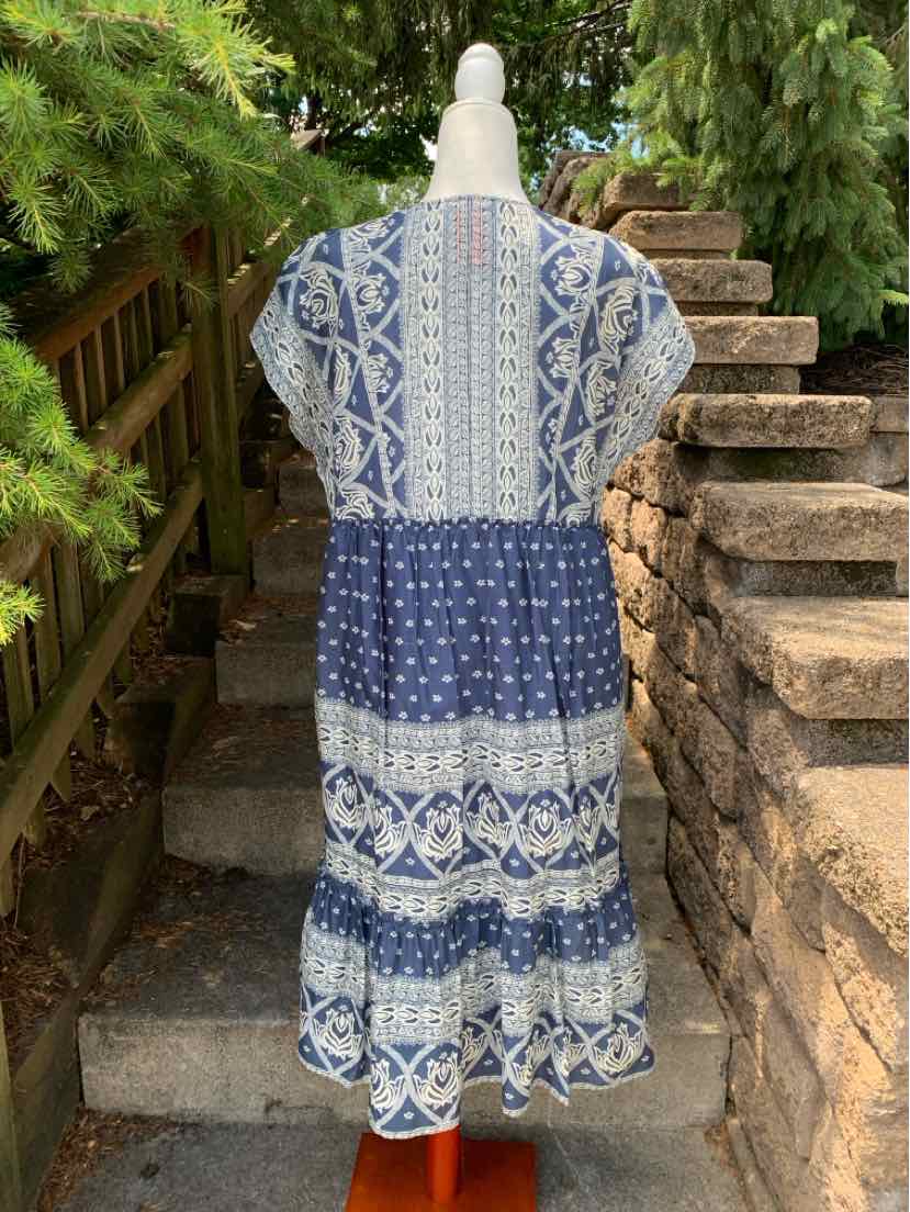 Boho-style midi dress with blue and white patchwork pattern, short sleeves, and tiered skirt.