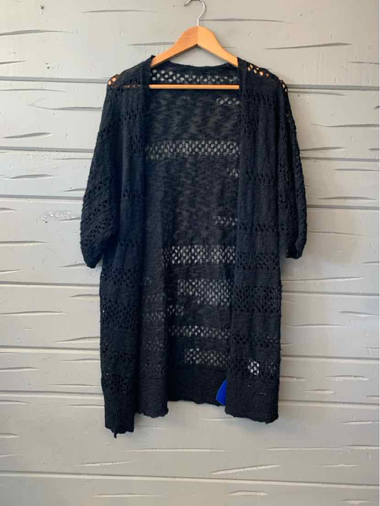Black open-knit cardigan with three-quarter sleeves, longline silhouette, and a scalloped hem.