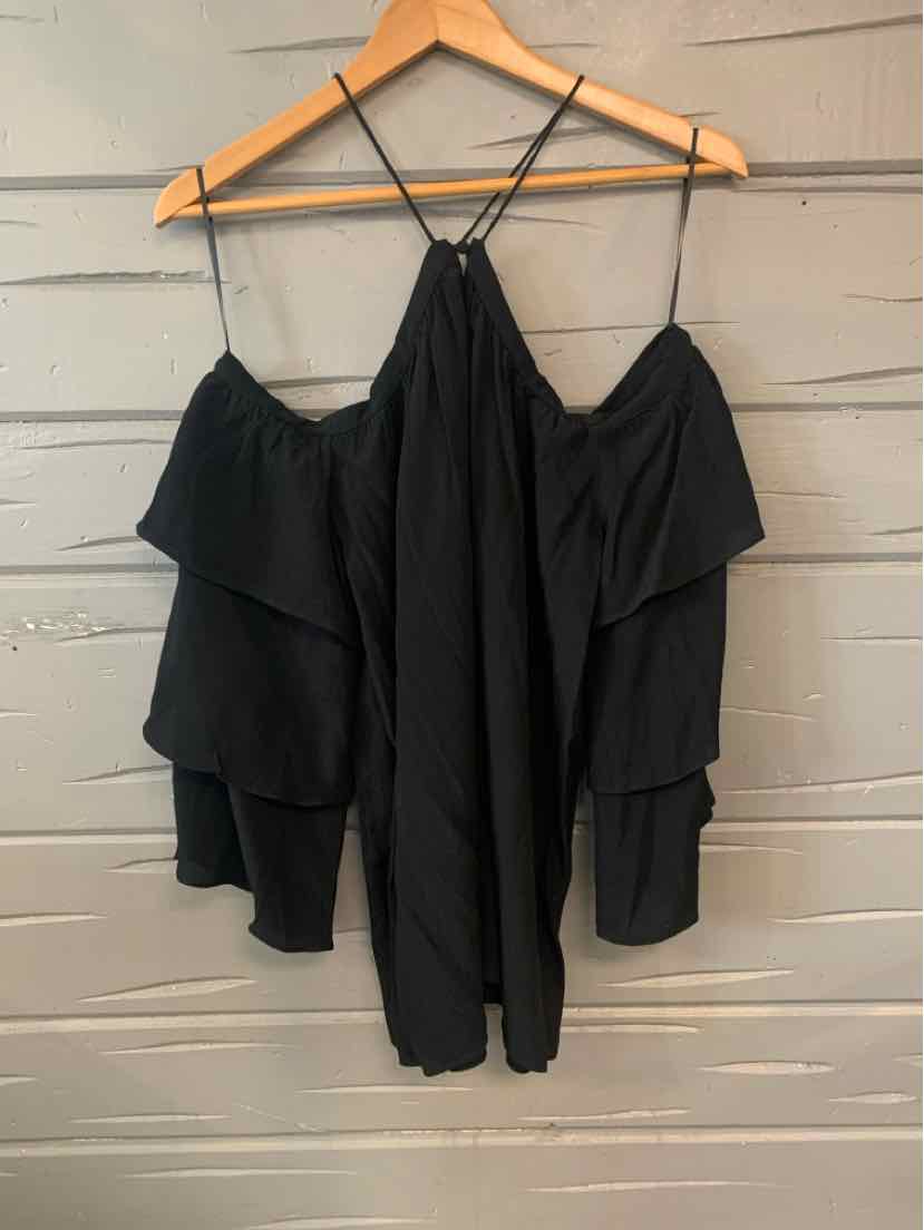 Black off-shoulder blouse with layered ruffle sleeves and thin straps on wooden hanger.