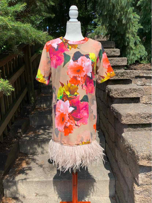 Short-sleeve floral dress in beige with bright pink and orange flowers, feather trim hem.