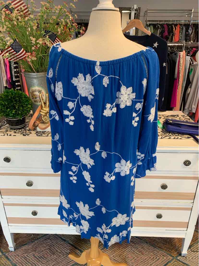 Blue floral off-shoulder blouse with white flowers and three-quarter sleeves on dress form.