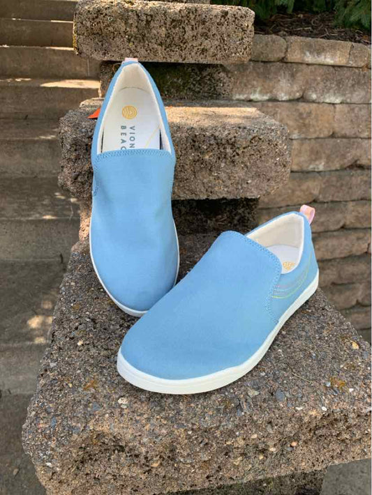 Light blue slip-on shoes with white soles, round toes, and elastic side panels.