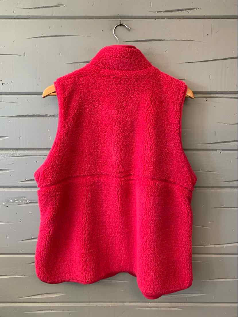 Bright pink sleeveless fleece vest with a high collar and rounded hem, shown from the back.