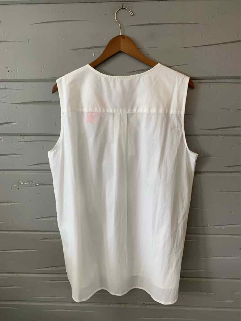 Sleeveless white blouse in solid fabric with a round neckline and a back yoke seam.