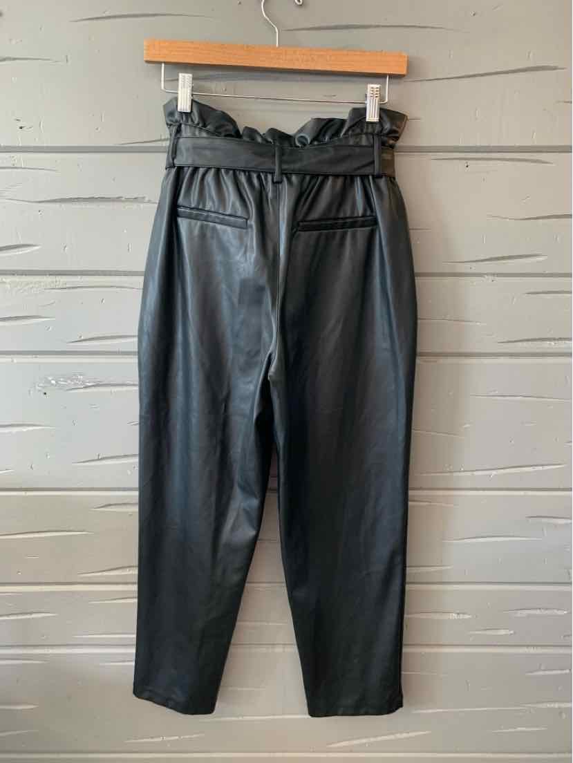 Black high-waist paperbag trousers with pleated waistband and tapered legs.