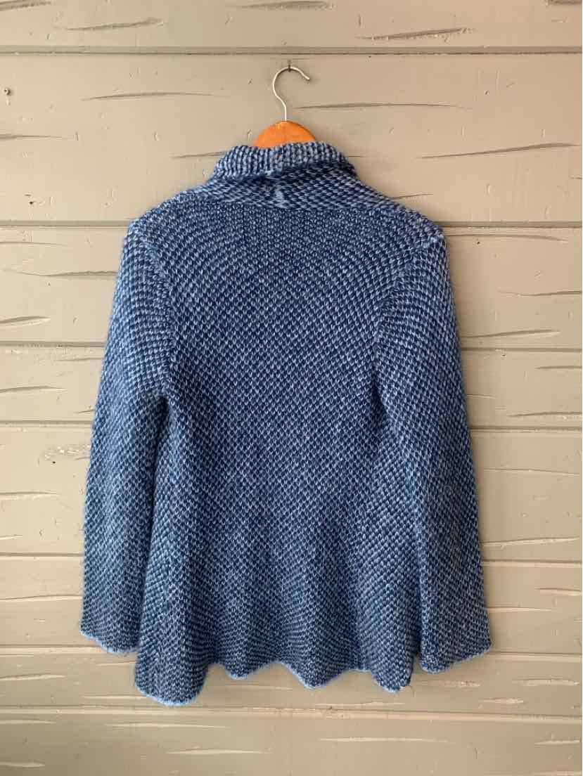 Blue knitted sweater with high collar and long sleeves hanging on wooden hanger.