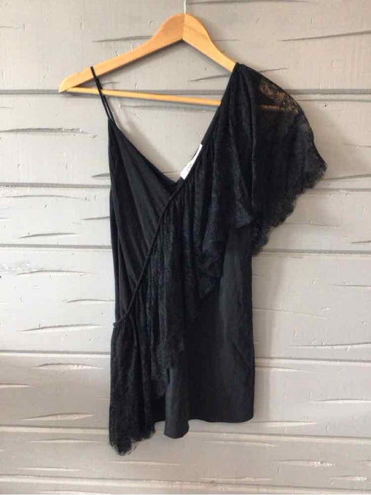 Black asymmetrical mini dress with lace detailing and thin shoulder straps on a wooden hanger.