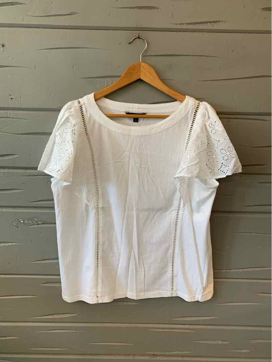 White short-sleeve blouse with round neckline and lace detailing on sleeves, cotton fabric.
