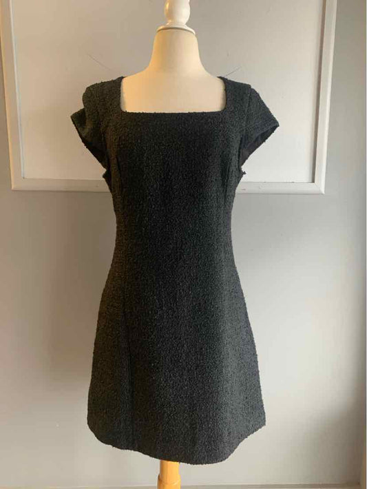 Black tweed mini dress with square neckline and short sleeves on mannequin.