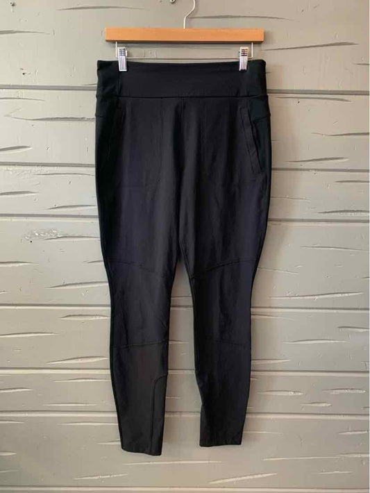 Black high-waisted athletic leggings with fitted ankle cuffs and side pockets.