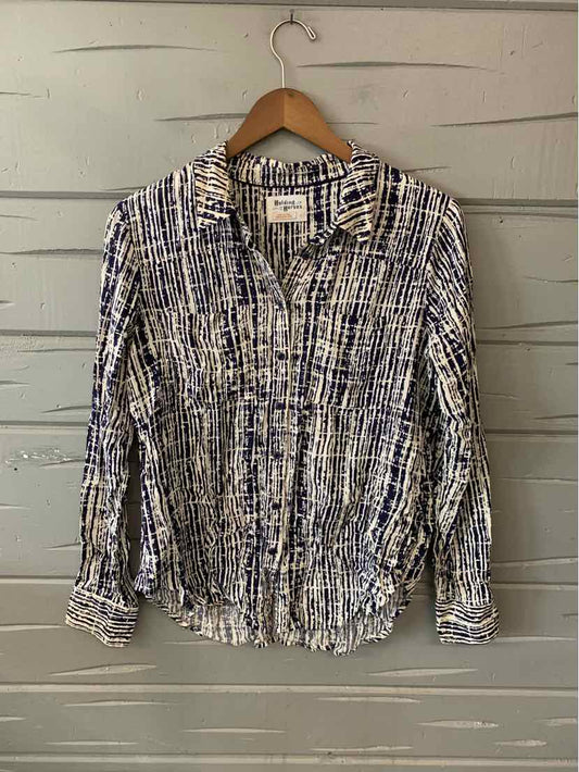 Long-sleeve button-up shirt with abstract black, white, and blue pattern on light fabric.