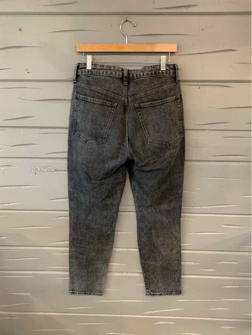 Black acid-wash denim jeans with high waist and back pockets, size 6 hanging on wooden hanger.