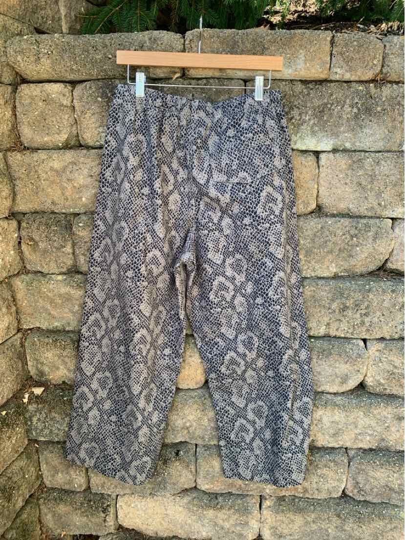 Gray animal print pants with elastic cuffs and a relaxed fit, hanging on wooden hanger.