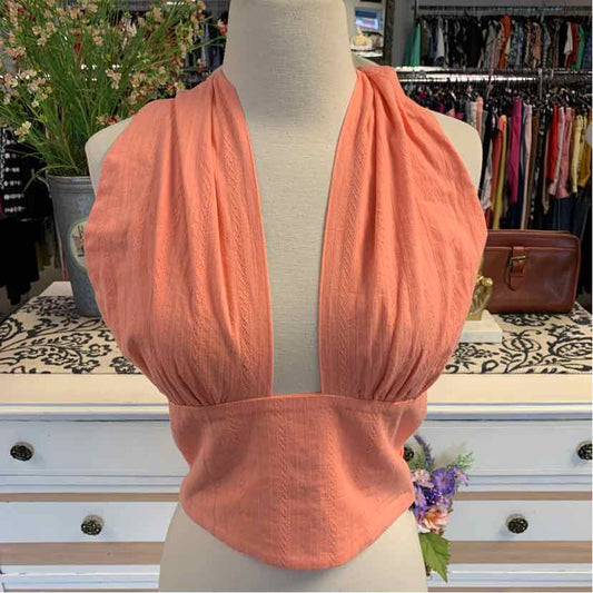 Coral orange sleeveless wrap top with deep V-neck and gathered waist details on mannequin.