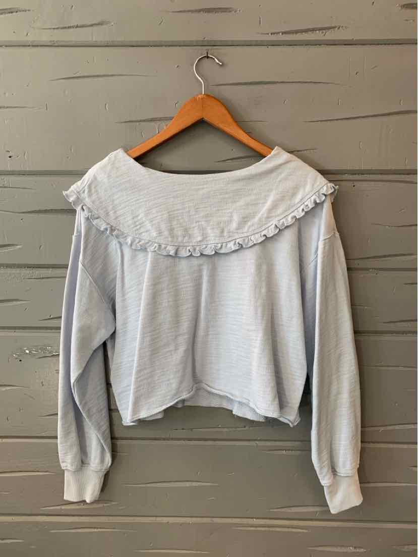 Light blue long-sleeve cropped sweater with ruffled neckline and ribbed cuffs on wooden hanger.