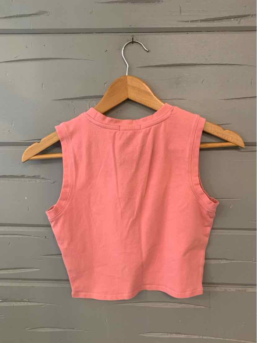 Sleeveless cropped pink top with high round neckline hanging on wooden hanger.