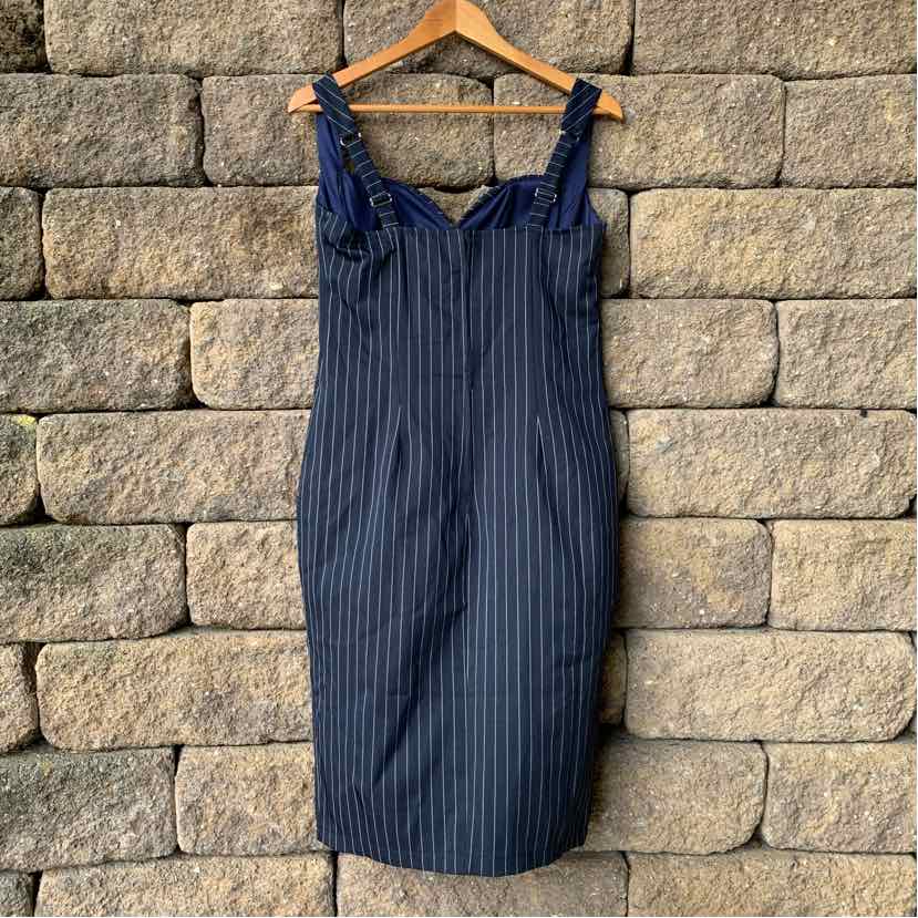 Navy blue pinstripe sleeveless dress with ruffled straps and fitted midi silhouette.