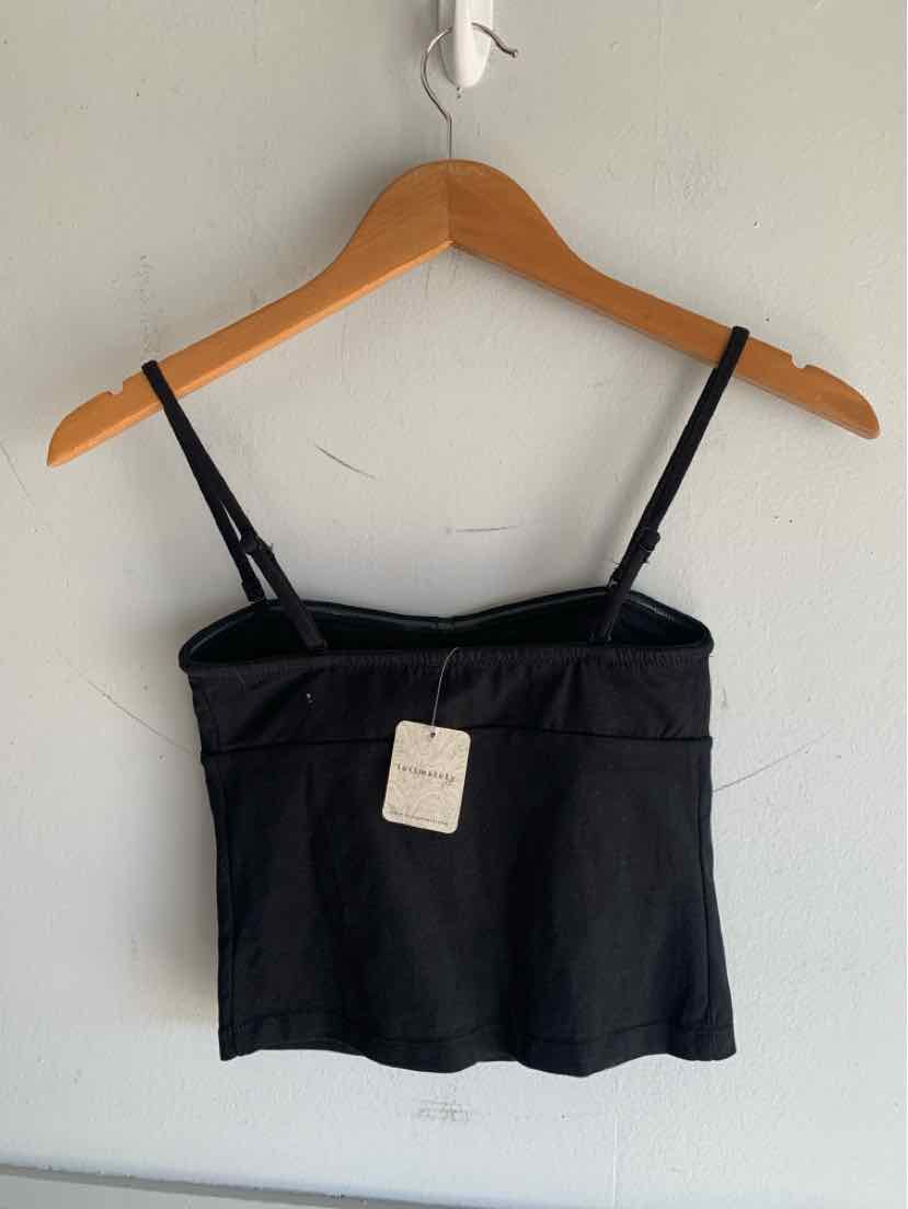 Black fitted cropped camisole with adjustable thin straps on wooden hanger.