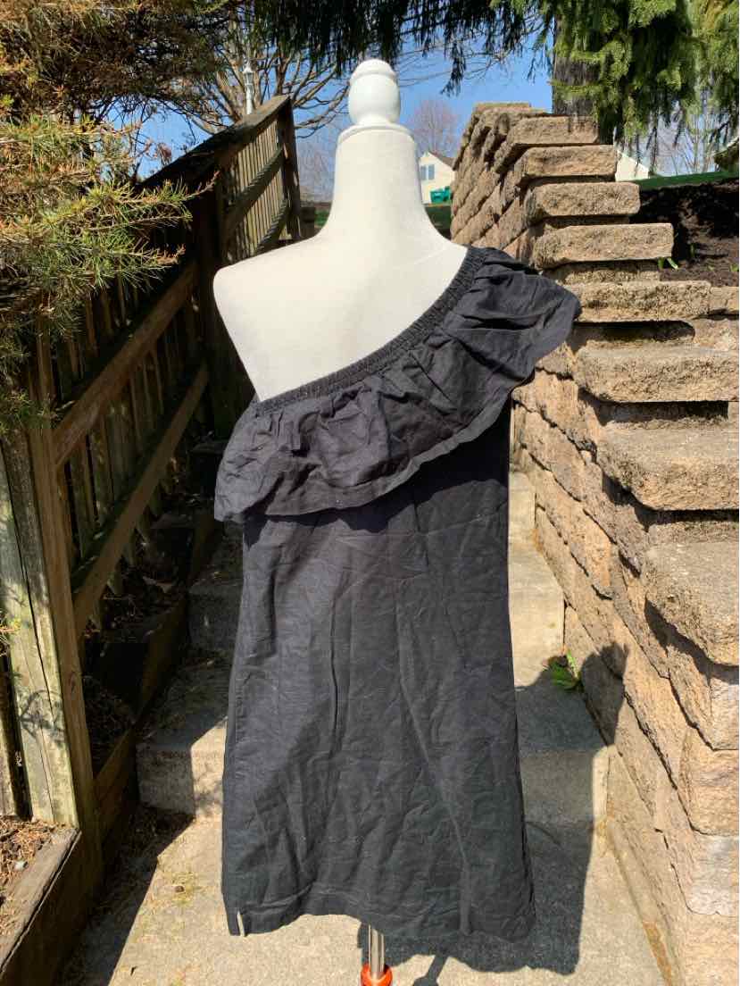 Black one-shoulder dress with ruffled neckline and knee-length hem on mannequin.
