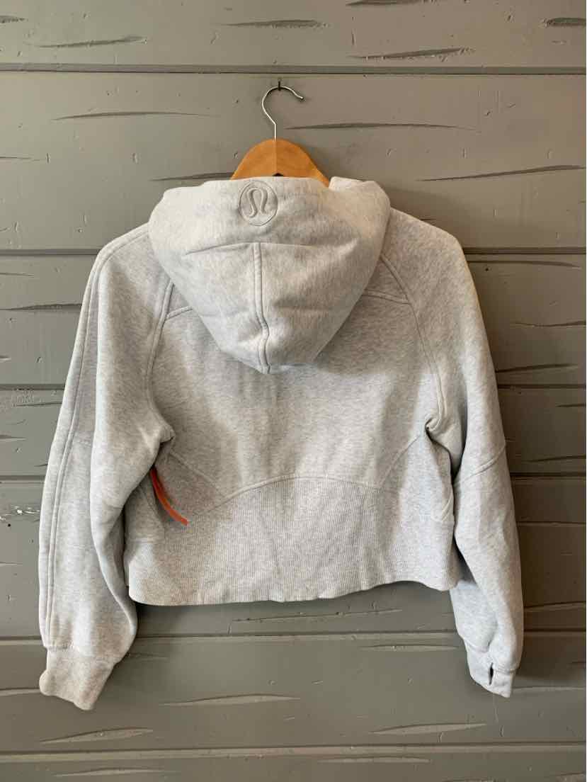 Light gray cropped hoodie with long sleeves and front pockets, soft fabric, fitted style.