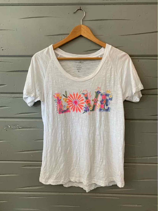 White short-sleeve cotton T-shirt with colorful "LOVE" graphic and floral designs on front.