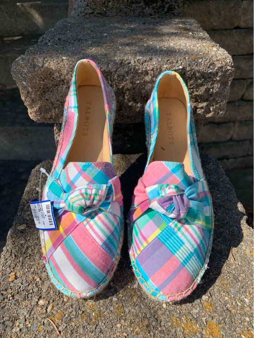 Multi-color plaid slip-on shoes with rounded toes and bow accents, size 7.