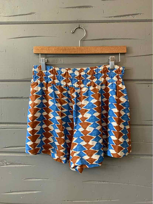 High-waisted shorts with a blue, white, and brown geometric zigzag pattern on lightweight fabric.