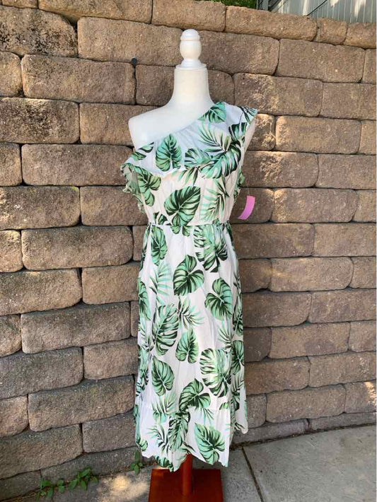 White tropical-print sleeveless midi dress with green palm leaves, fitted waist, and ruffle neckline.