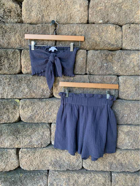 Navy blue two-piece set with a cropped tie-front top and high-waisted shorts with a ruffled hem.
