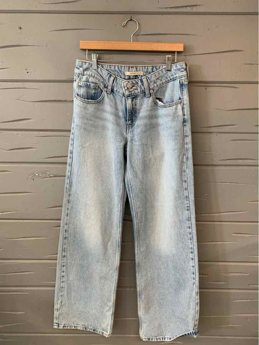 Light blue high-waisted Levi's denim jeans with straight legs and classic five-pocket design hanging on wooden hanger.