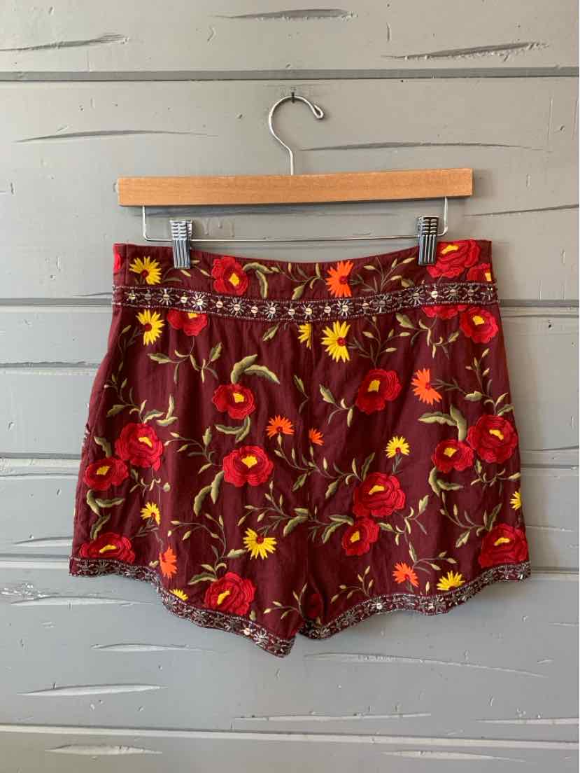 Burgundy floral skort with red and yellow flower print, high waist, button closure, and short length.