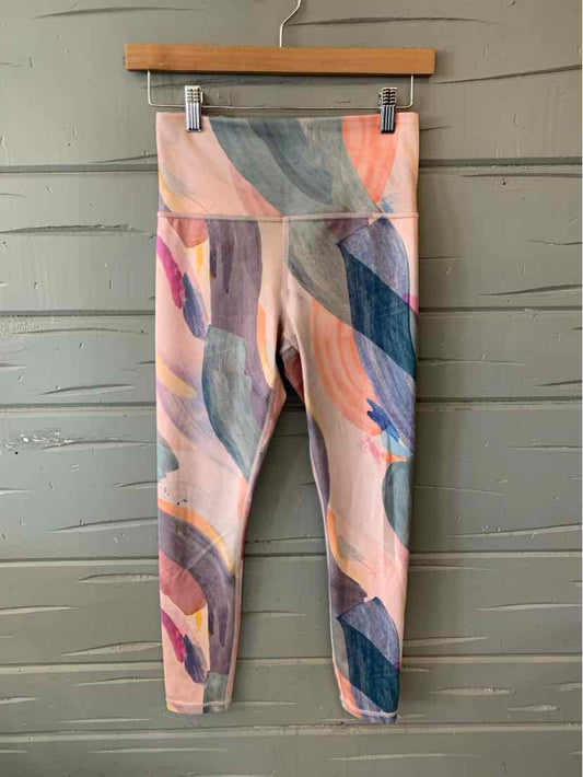 High-waist leggings with abstract multi-color brushstroke pattern in pink, blue, and peach tones.