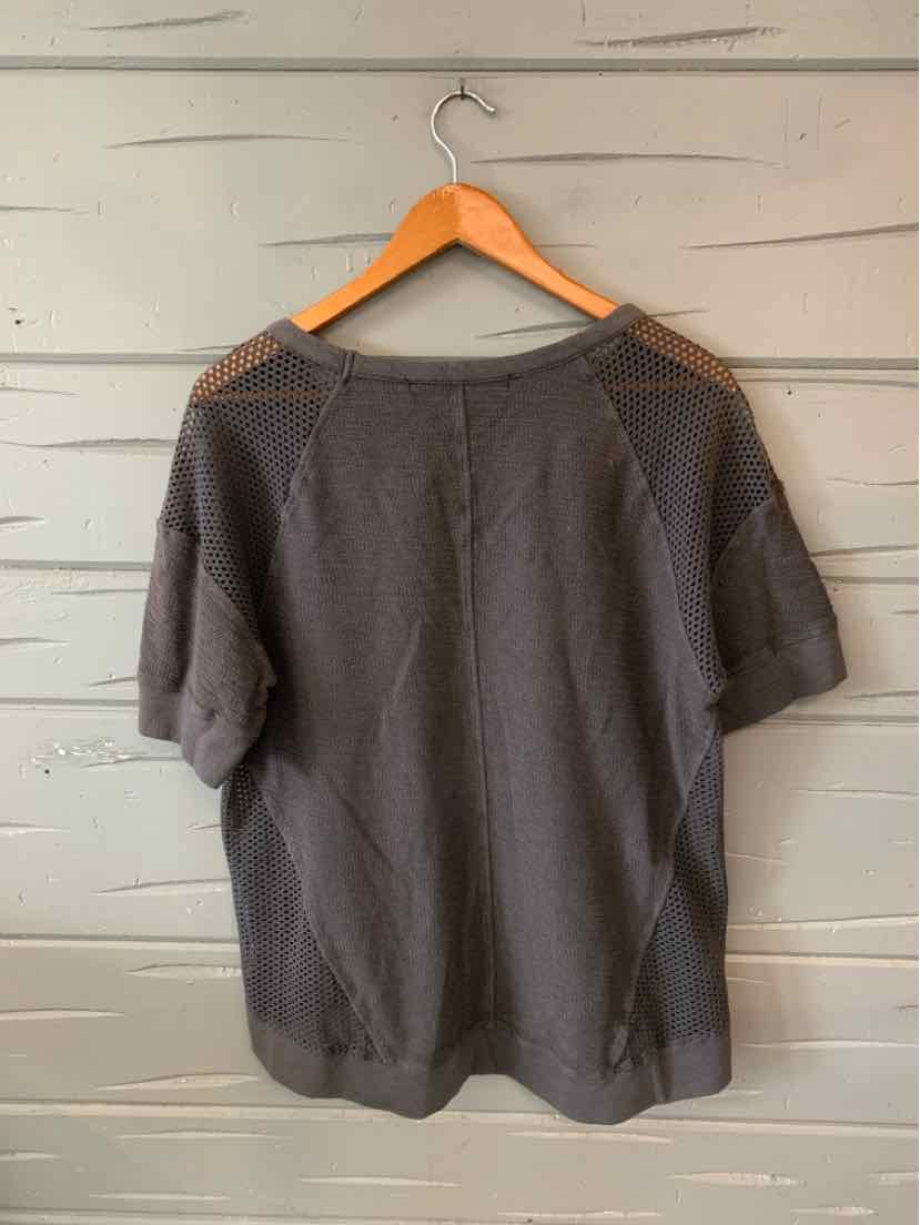 Charcoal gray short-sleeve oversized knit top with a round neckline and relaxed fit on wooden hanger.