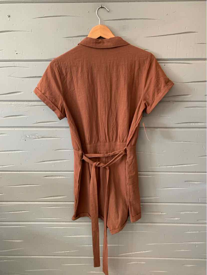 Rust-colored short-sleeve shirt dress with a collar and a waist tie belt hanging on a wooden hanger.