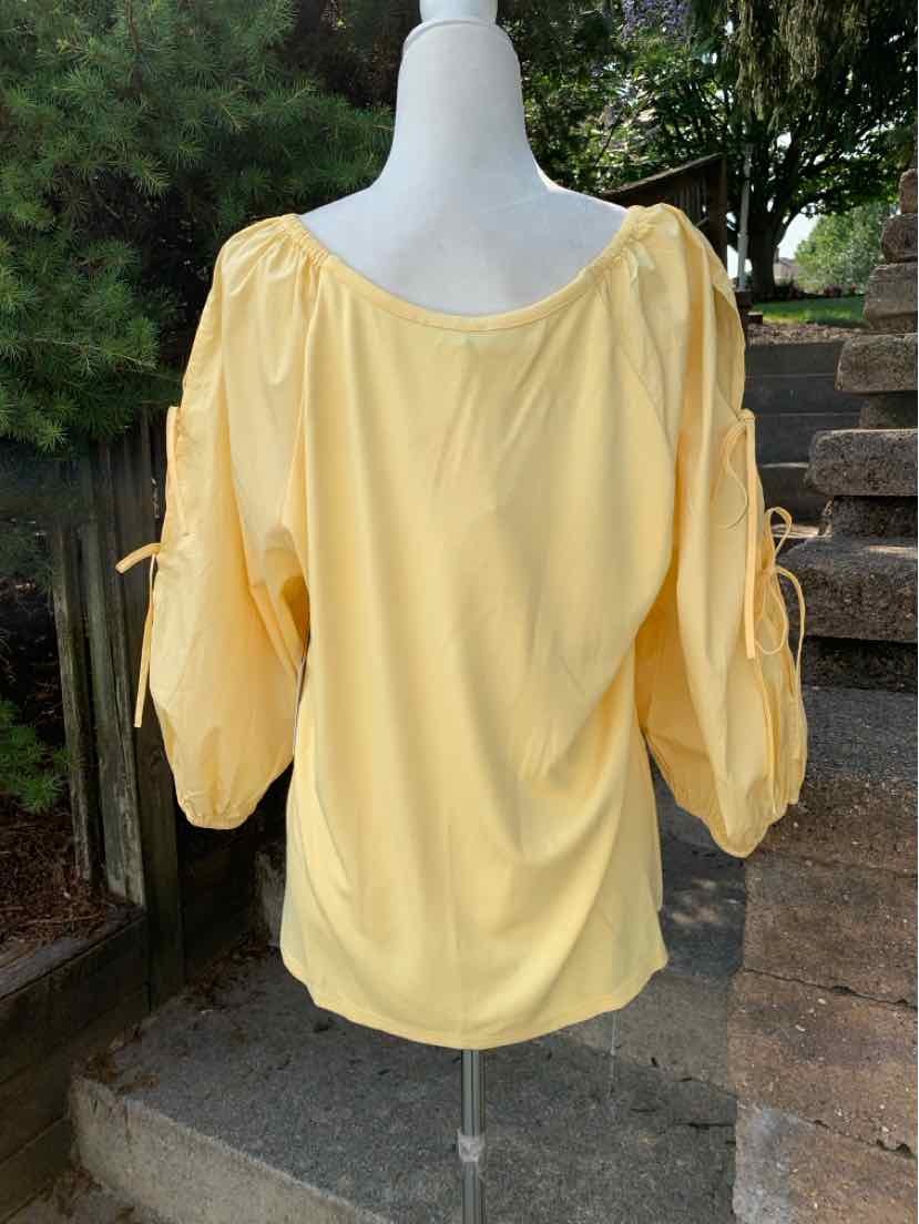 Light yellow women's blouse with billowy three-quarter sleeves and gathered neckline.