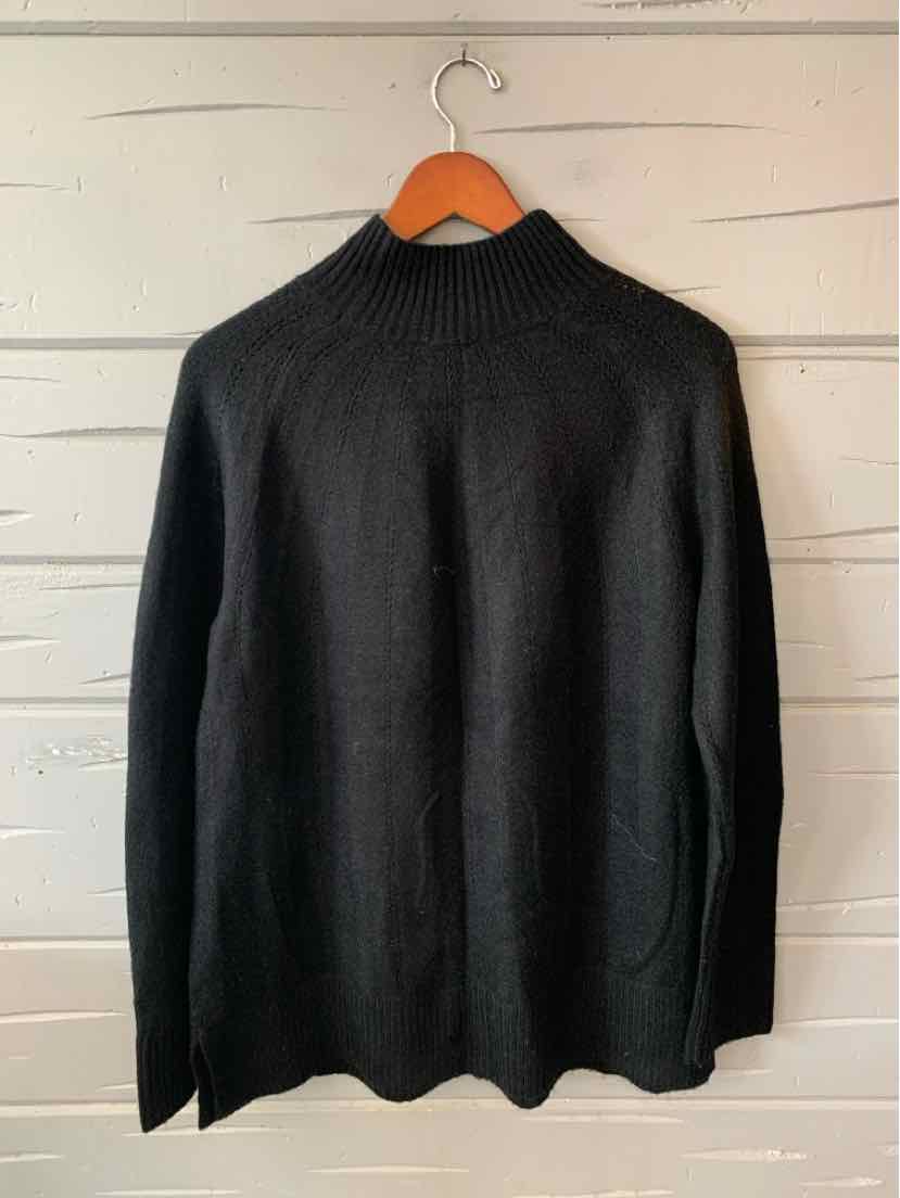 Black Talbots women’s sweater with long sleeves and a ribbed mock neck, hanging on a wooden hanger.