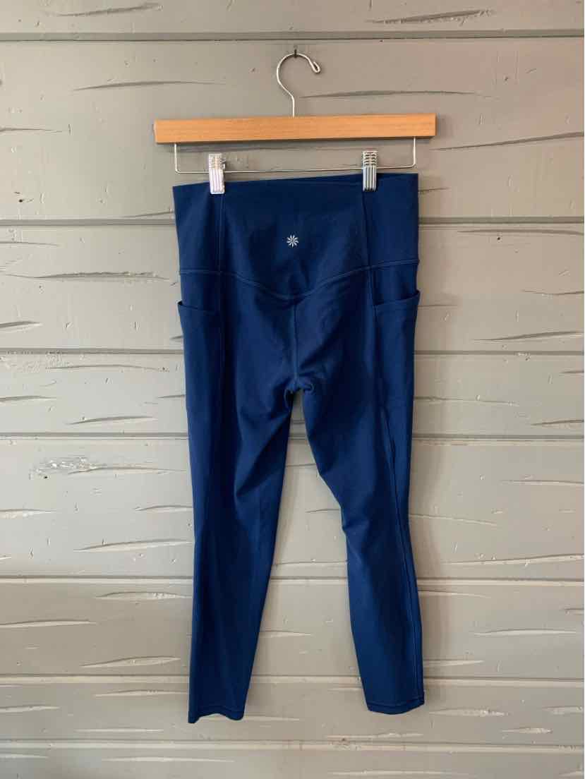 Navy blue high-waisted athletic leggings with side pockets and a small logo on the back waistband.