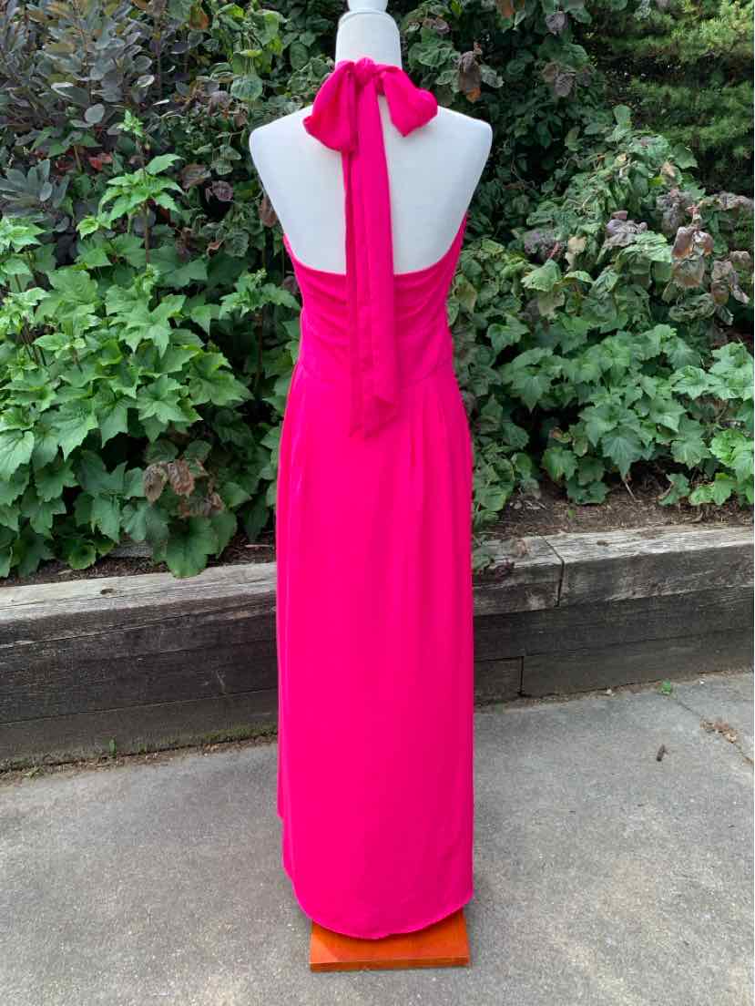 Bright pink halter-neck maxi dress with a long tie at the neck and a fitted silhouette.