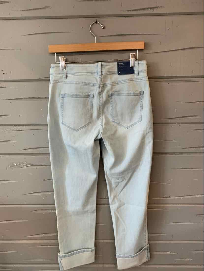 Light wash denim jeans with rolled cuffs and back pockets, size 4.