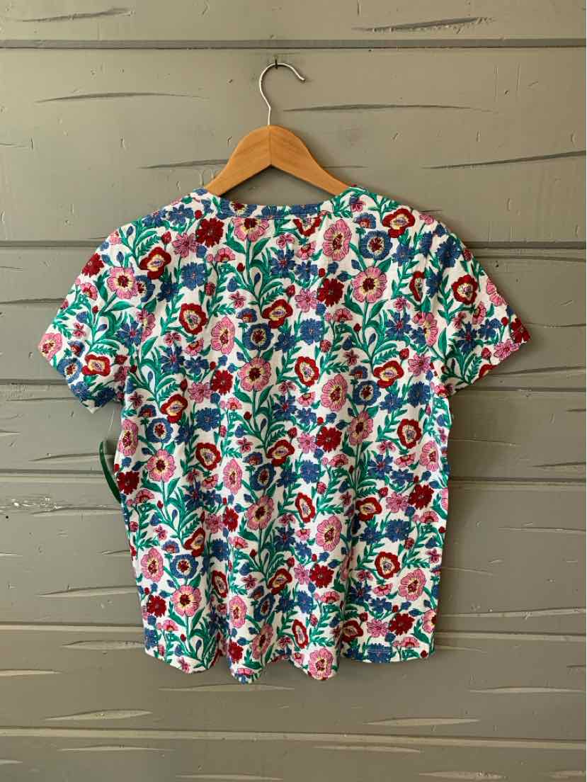 Short-sleeve crewneck shirt with vibrant multicolor floral print on white background.