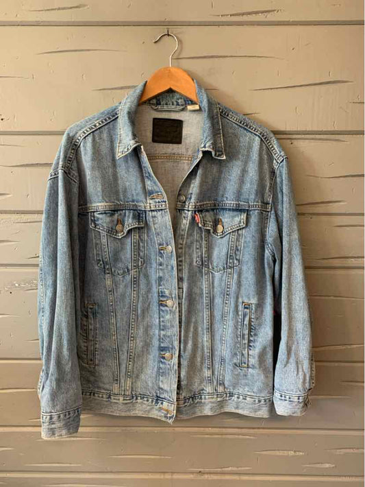 Light blue denim Levi's jacket with button front and chest pockets hanging on wooden hanger.