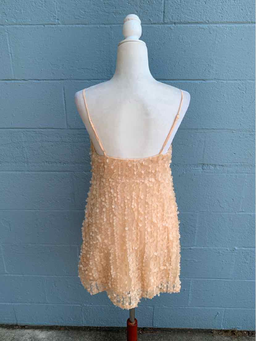 Peachy beige floral lace camisole with thin spaghetti straps and a slightly flared hem.