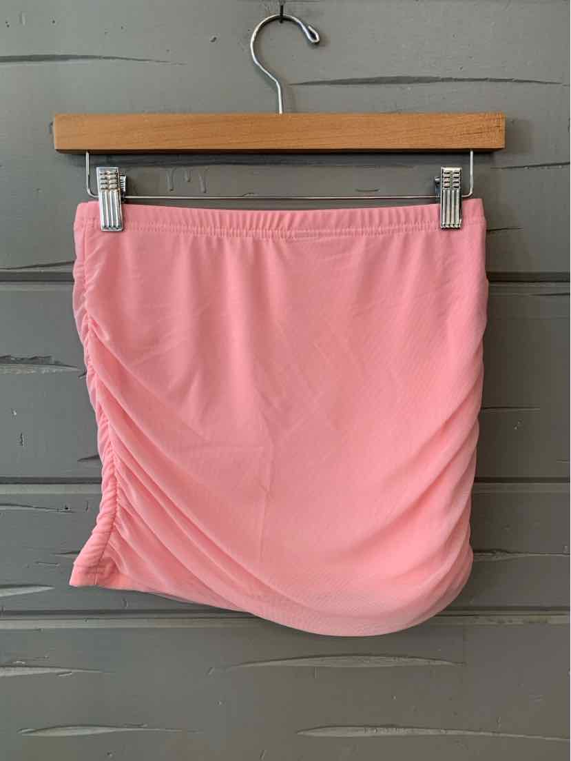 Soft pink mini skirt with ruched detailing on one side, smooth fabric, elastic waistband.