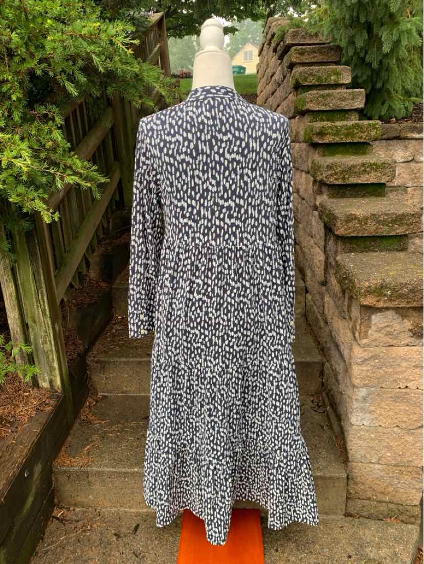 Long-sleeve midi dress with black and white polka dot pattern, fitted waist, and flowing skirt.