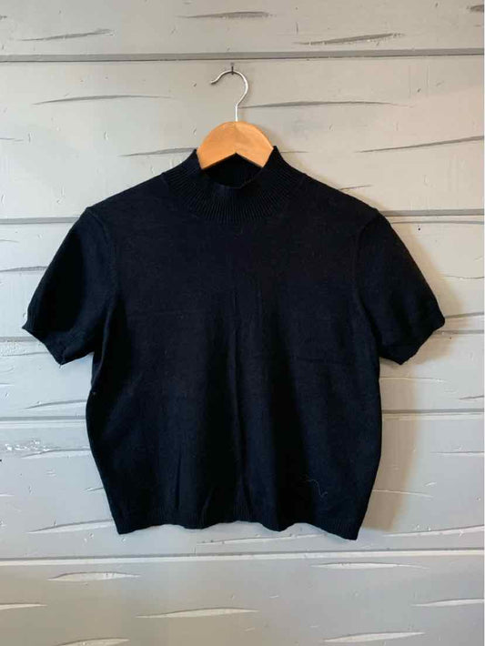 Black short-sleeve knit top with crew neck and ribbed hem, hanging on wooden hanger.