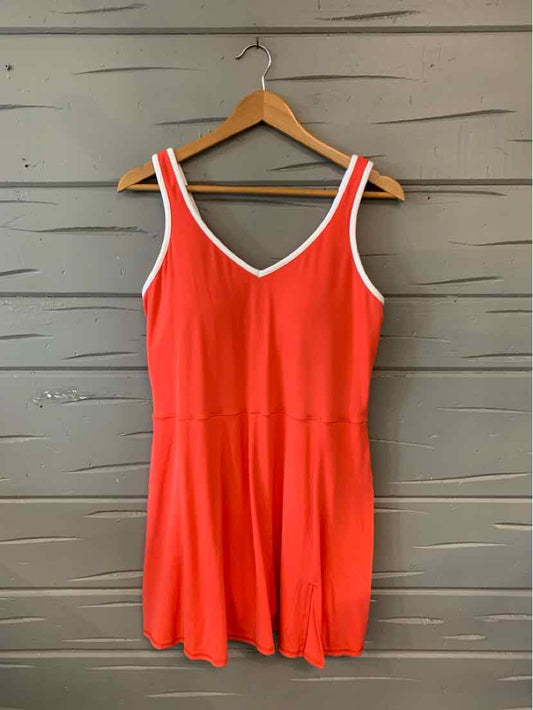 Sleeveless bright red dress with white trim neckline and fitted waist, hanging on wooden hanger.